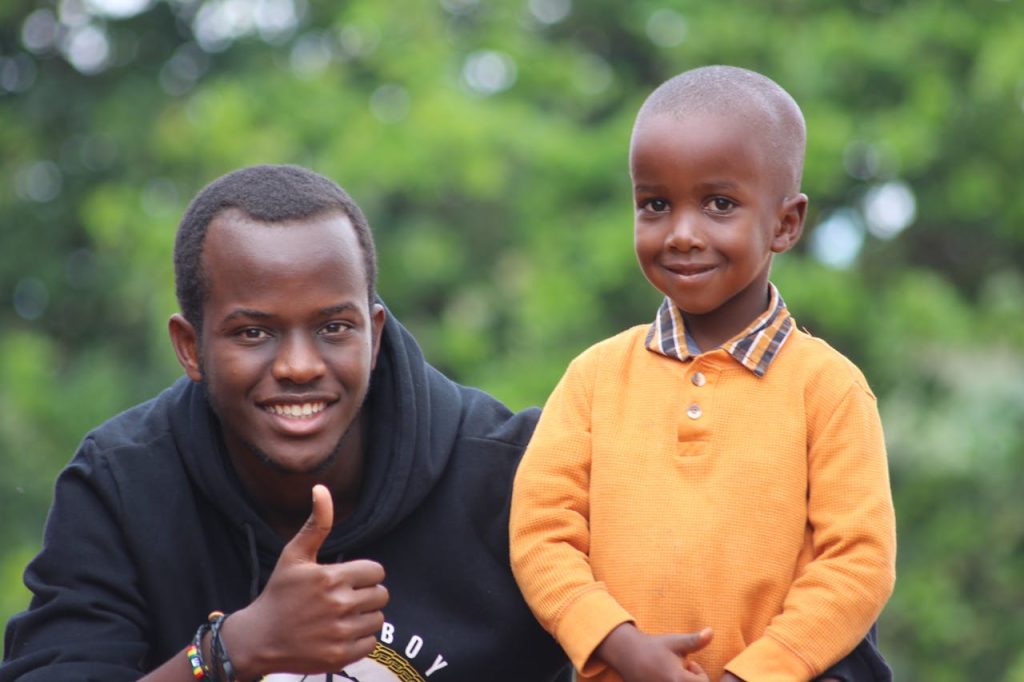 Smiling adult and child in colorful outdoor portrait in Gitega, Burundi.