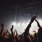 About Vibrant concert atmosphere with cheering crowd under spotlights and lively music.