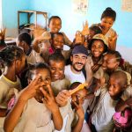About A group of smiling students in a lively classroom setting enjoying a moment of fun and happiness.